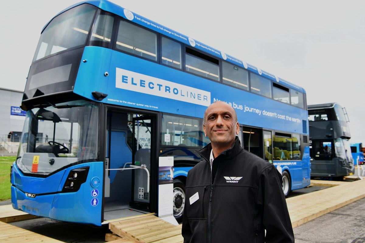 Photo of Wrightbus CEO Buta Atwal standing infront of an electroliner double deck bus