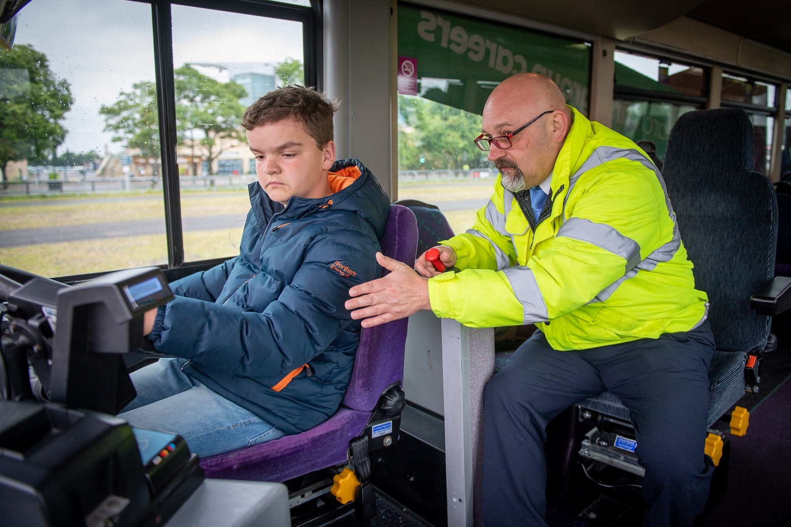 Young person tries his hand at driving a bus