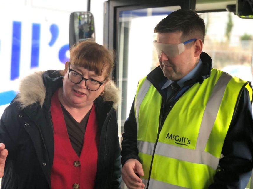 Eileen of RNIB Scotland guiding a trainee driver with sim specs on mcgills (1)